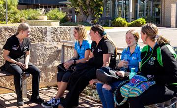 Students sitting on a bench and chatting